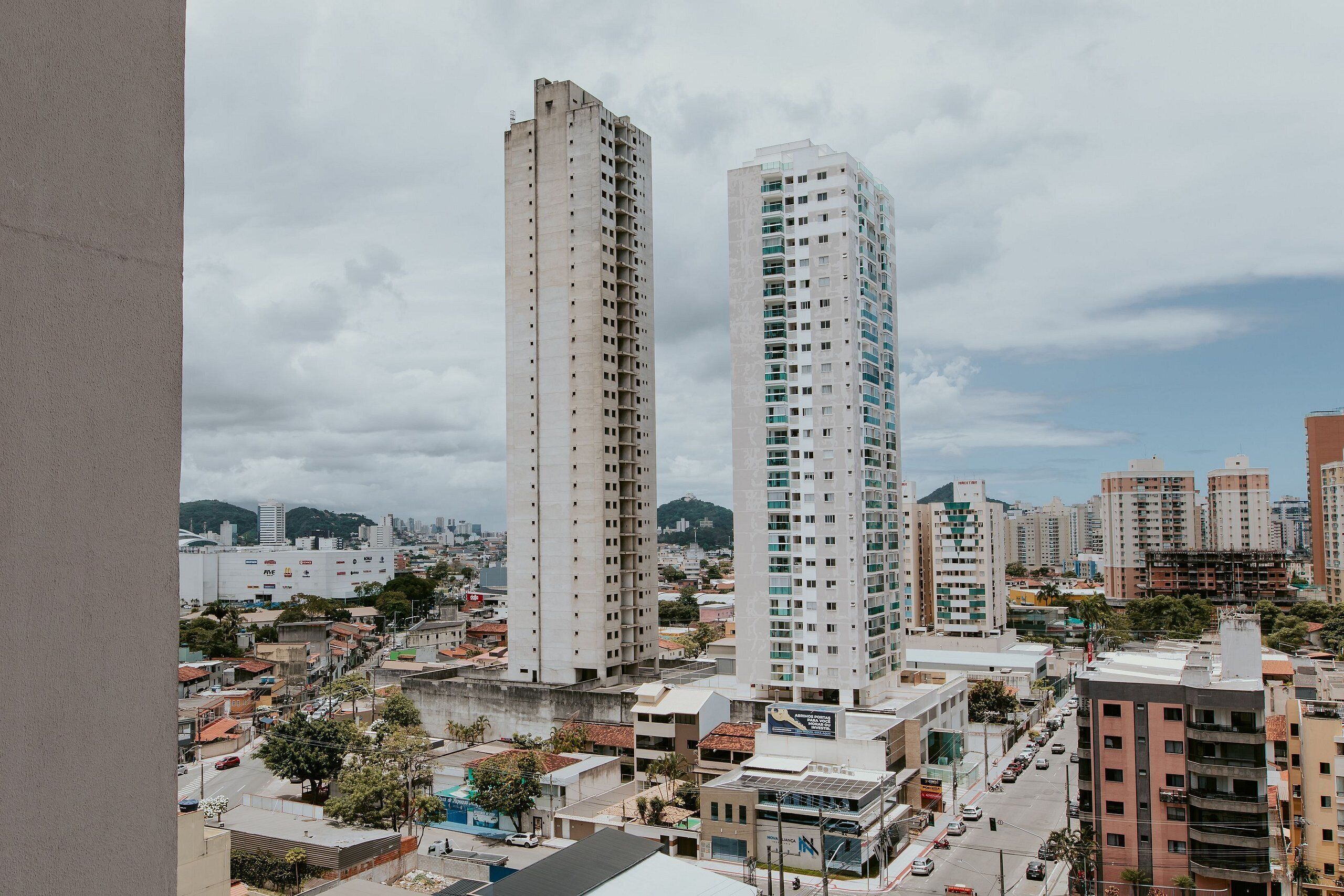 Un paisaje urbano con edificios altos, un río y una montaña distante.
