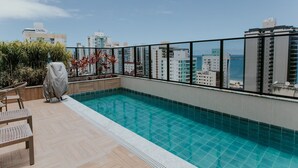 Una piscina en la azotea con vistas a la ciudad y al mar.
