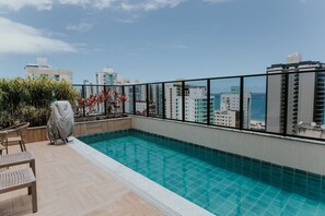 Una piscina al terrat amb vistes a la ciutat i al mar.