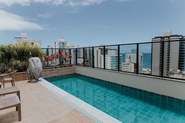 Ein Pool auf dem Dach mit Blick auf die Stadt und das Meer.