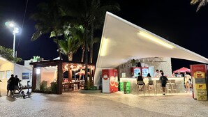 Een terras met tafels en stoelen, een kiosk en een overdekt zitgedeelte.