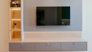 Een moderne entertainmentkast met een flatscreen televisie, inbouwplanken en kastjes.