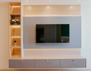 Ein modernes Unterhaltungselement mit Flachbildfernseher, integrierten Regalen und Schränken.