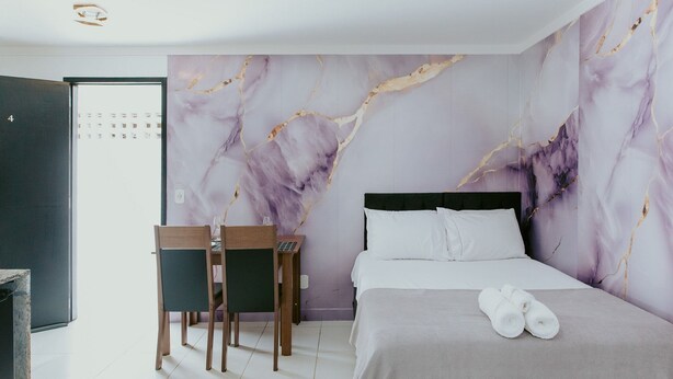 Een hotelkamer met een bed, een bureau, een stoel en een deur.