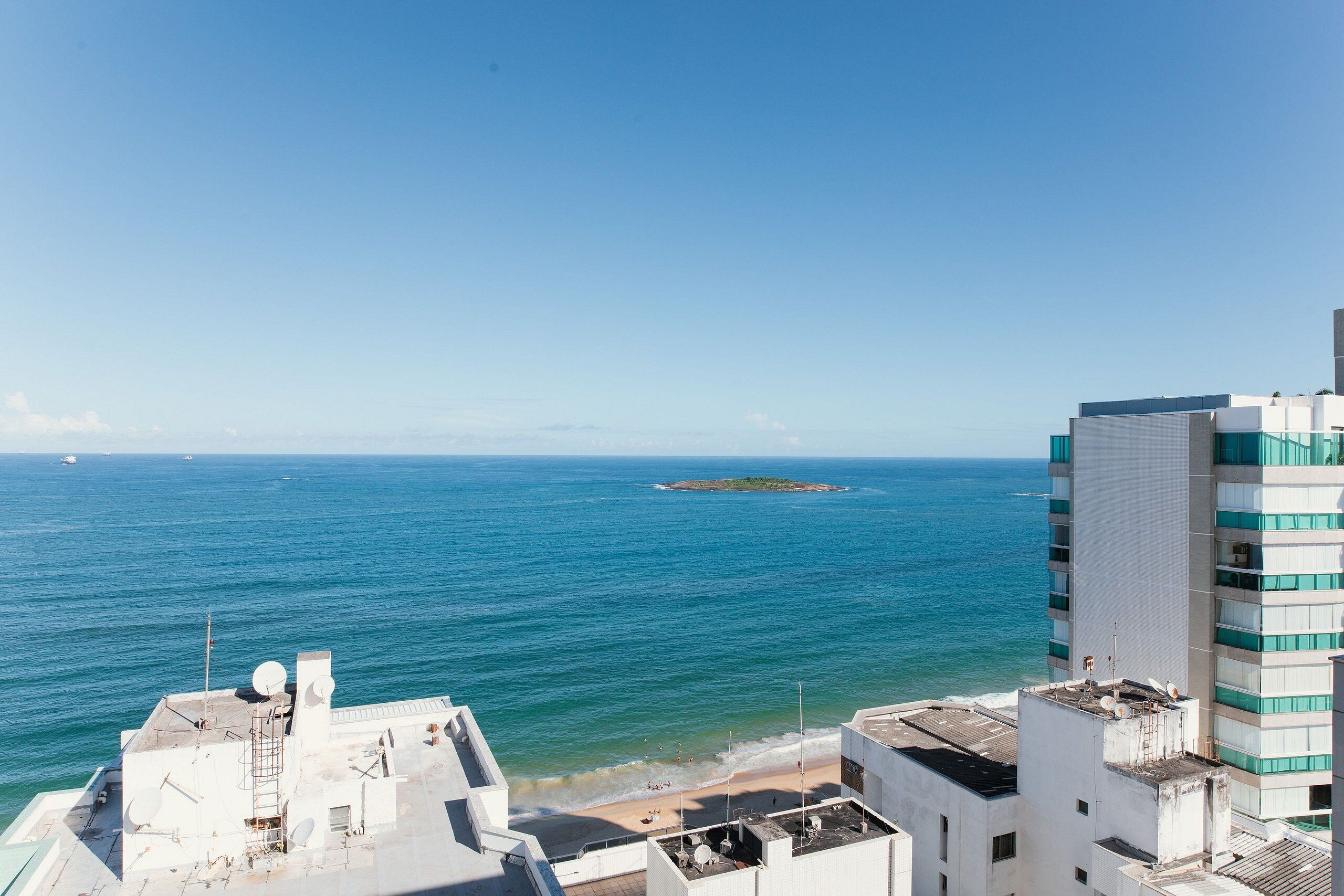 A coastal view with buildings, a beach, and the sea.
