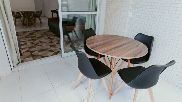 Een vergaderruimte met een ronde tafel, vier stoelen en een glazen scheidingswand.