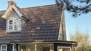 Ein Haus mit überdachter Veranda, Schornstein und Fenster.