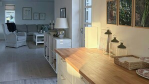 Eine moderne Küche mit Holzarbeitsplatten, einem eingebauten Backofen und einem Essbereich mit Sofa und Tisch.