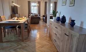 A modern living space with a dining area, sofas, a wooden cabinet, and a TV. - Holiday Apartment Henry – A Break Beneath Historic Beams (Arnstadt)