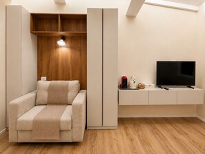 Una sala de estar moderna con un sofá, un televisor sobre un mueble bajo y un panel de pared de madera.