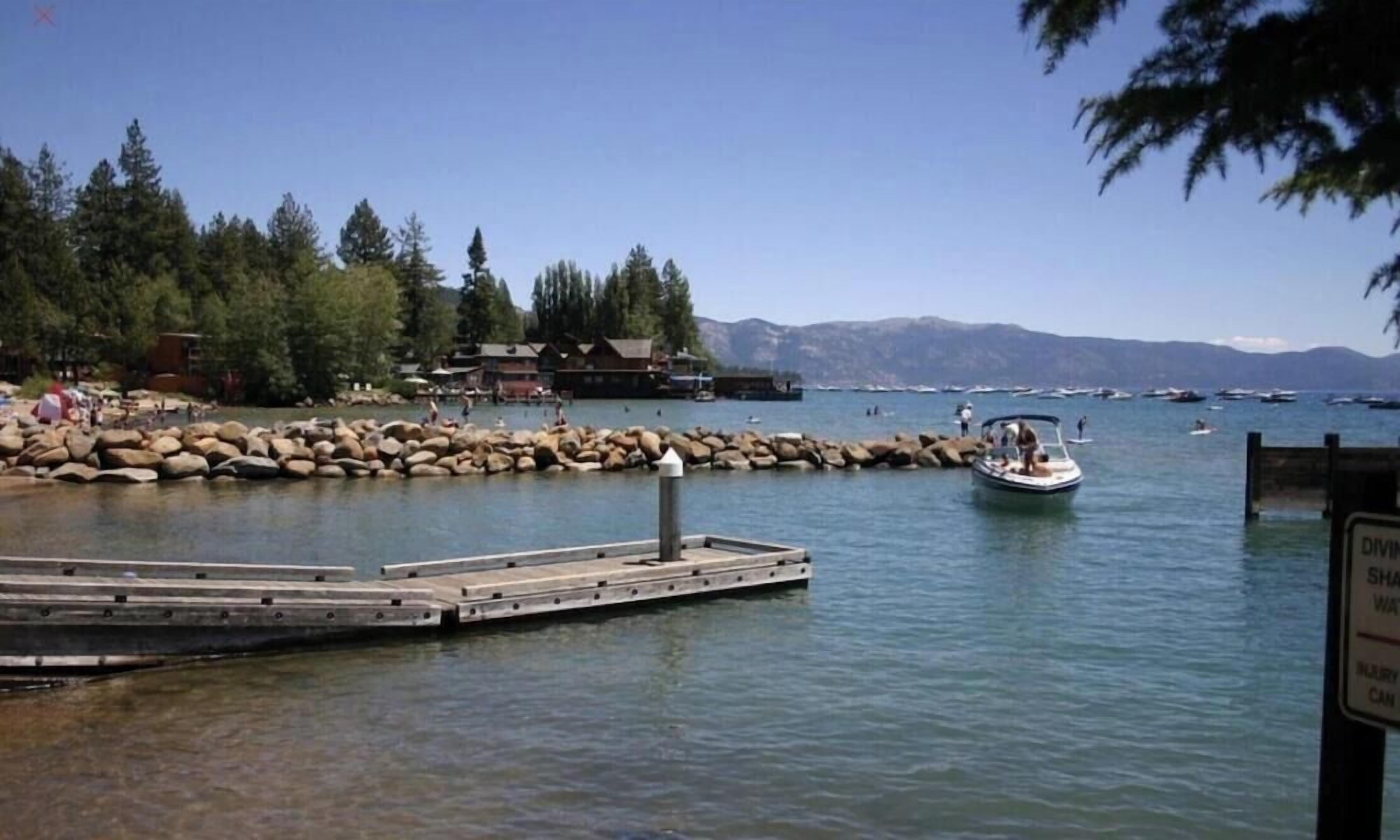 A dock with a boat, a pier, and a building with a wooden exterior.