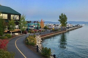 Ein Anwesen am Wasser mit gepflastertem Gehweg, einer Marina und einem Gebäude mit Gründach.