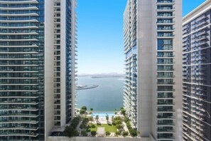 A high-rise building with a view of a body of water and a distant cityscape. - Sophisticated Sea View Retreat At Emaar Beachfront (Dubai)