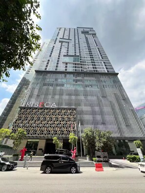 A tall, modern building with a glass facade and a geometric entrance design. - Chic Cityscape Stay in Bukit Bintang, TRX | 1-6pax (Kuala Lumpur)