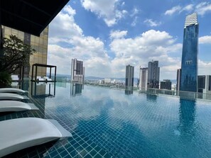 A rooftop infinity pool with a cityscape view, modern buildings, and a clear sky. - Chic Cityscape Stay in Bukit Bintang, TRX | 1-6pax (Kuala Lumpur)