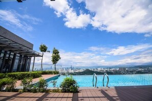 A rooftop pool with a city view, surrounded by greenery and a modern building structure. - Comfy Loft in EkoCheras, Link to MRT | 1-6 pax (Kuala Lumpur)