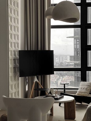 A modern living room with a large TV, a round coffee table, and a sofa. - Comfy Loft in EkoCheras, Link to MRT | 1-6 pax (Kuala Lumpur)