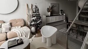 Ett modernt vardagsrum med en soffa, ett soffbord och en julgran.