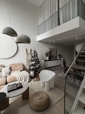 Ein modernes Wohnzimmer mit einer Couch, einem Couchtisch und einem Weihnachtsbaum.