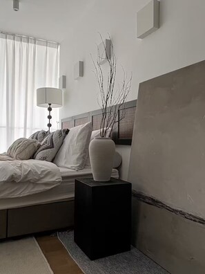 A bedroom with a bed, bedside lamp, vase, and a large painting on the wall. - Comfy Loft in EkoCheras, Link to MRT | 1-6 pax (Kuala Lumpur)