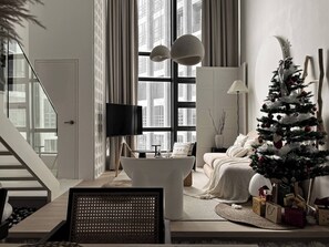 A modern living room with a staircase, a flat-screen TV, a Christmas tree, and a cozy seating area. - Comfy Loft in EkoCheras, Link to MRT | 1-6 pax (Kuala Lumpur)