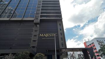 A tall building with a modern design, featuring a prominent 'MAJESTIC RESIDENCE' sign.