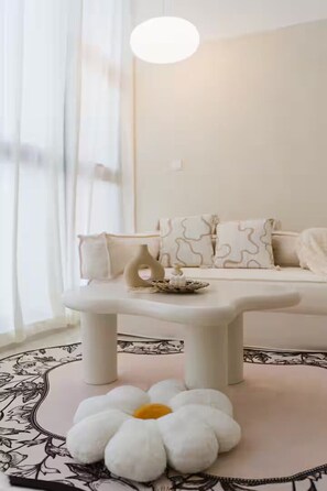 Un salon moderne avec un canapé, une table basse et un tapis décoratif en forme de fleur.