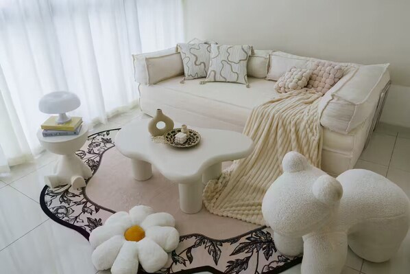 A living room with a sofa, coffee table, and decorative items. - Cozy Cityscape Stay in KLCC, Quill Mall | 1-5 pax (Kuala Lumpur)