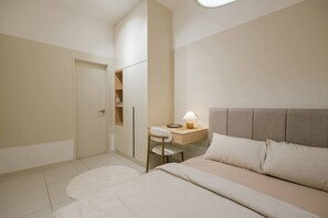 A bedroom with a bed, bedside table, lamp, and a wardrobe. - Cozy Cityscape Stay in KLCC, Quill Mall | 1-5 pax (Kuala Lumpur)