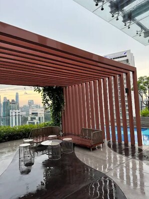 Een terras met uitzicht op de stadshemel, een zwembad en een modern architectonisch ontwerp.