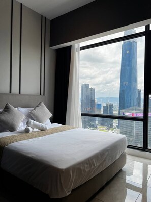 A modern hotel room with a large bed, a view of a cityscape, and a large window. - Rare Cityscape Stay in Bukit Bintang, TRX | 1-6pax (Kuala Lumpur)