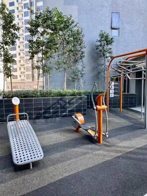 Een buiten trainingsruimte met een vlakke bank en een pull-up stang.