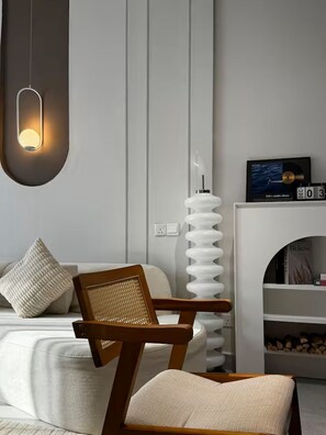 A modern bedroom with a bed, a wooden chair, a white lamp, and a fireplace. - Skyline & City Vibe in TRX, Bukit Bintang 1-5pax (Kuala Lumpur)