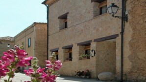 A stone building with multiple windows, a visible balcony, and a street lamp. - House for 16 next to Burgo de Osma.  Hiking, wine, castles. Pets (Alcubilla del Marqués)