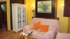 A living room with a sofa, a cabinet, a painting, and a staircase. - House for 16 next to Burgo de Osma.  Hiking, wine, castles. Pets (Alcubilla del Marqués)