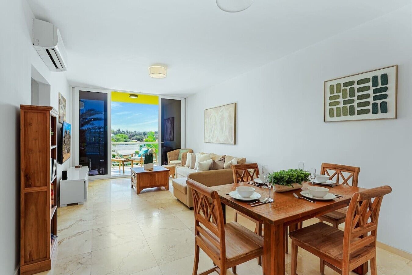 Un salon moderne avec un coin repas, de grandes fenêtres et une vue sur un paysage.
