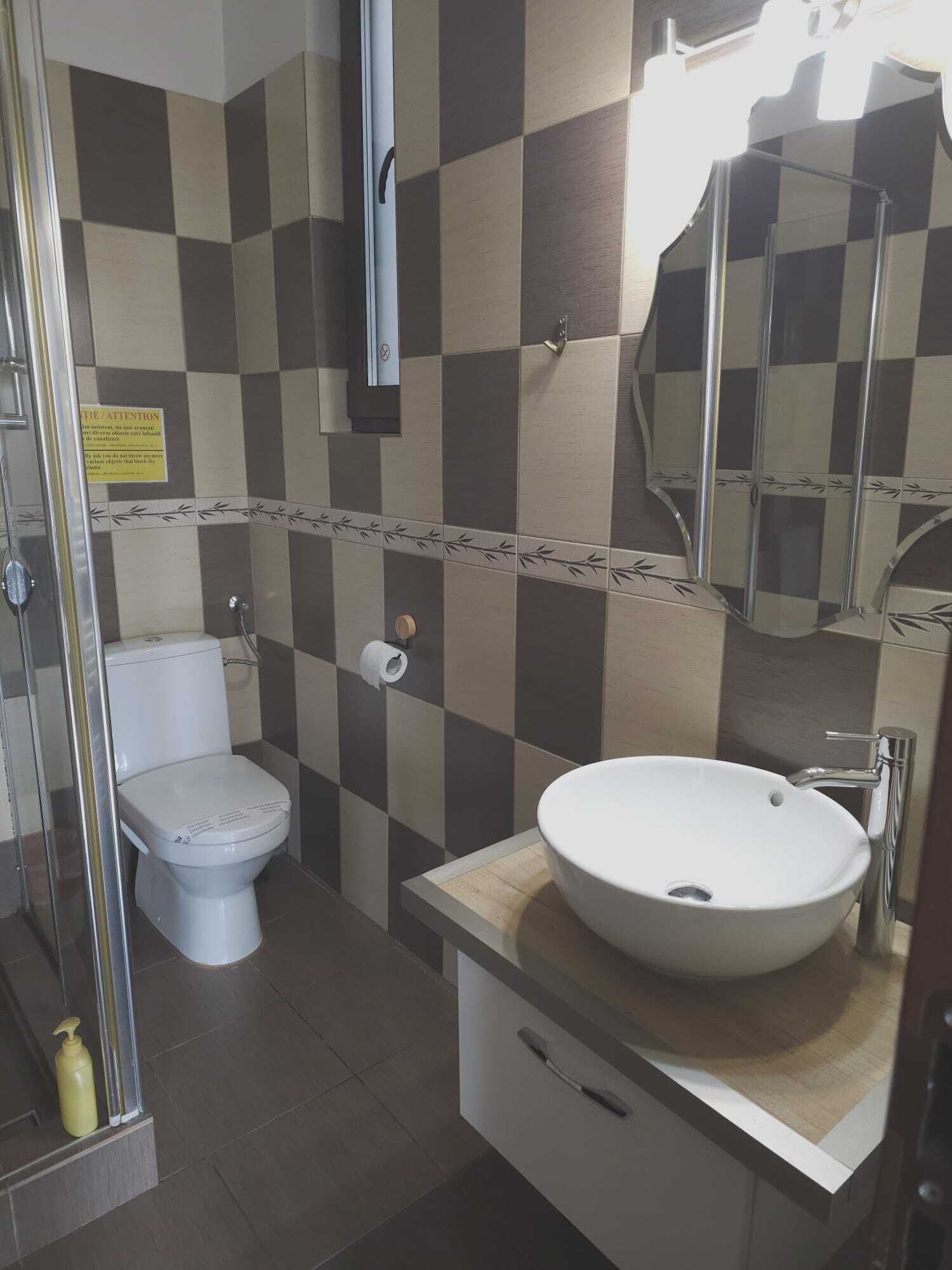 A bathroom with a toilet, sink, and shower.