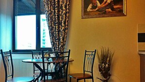 Un comedor con una mesa, sillas, un reloj y una ventana con cortinas.