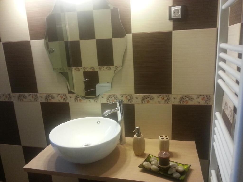 Une salle de bain avec un lavabo blanc, un miroir et un porte-serviettes.