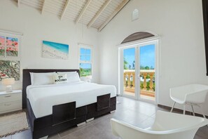 Ein Schlafzimmer mit Bett, Nachttisch, Stuhl, Fenster und einem Balkon.