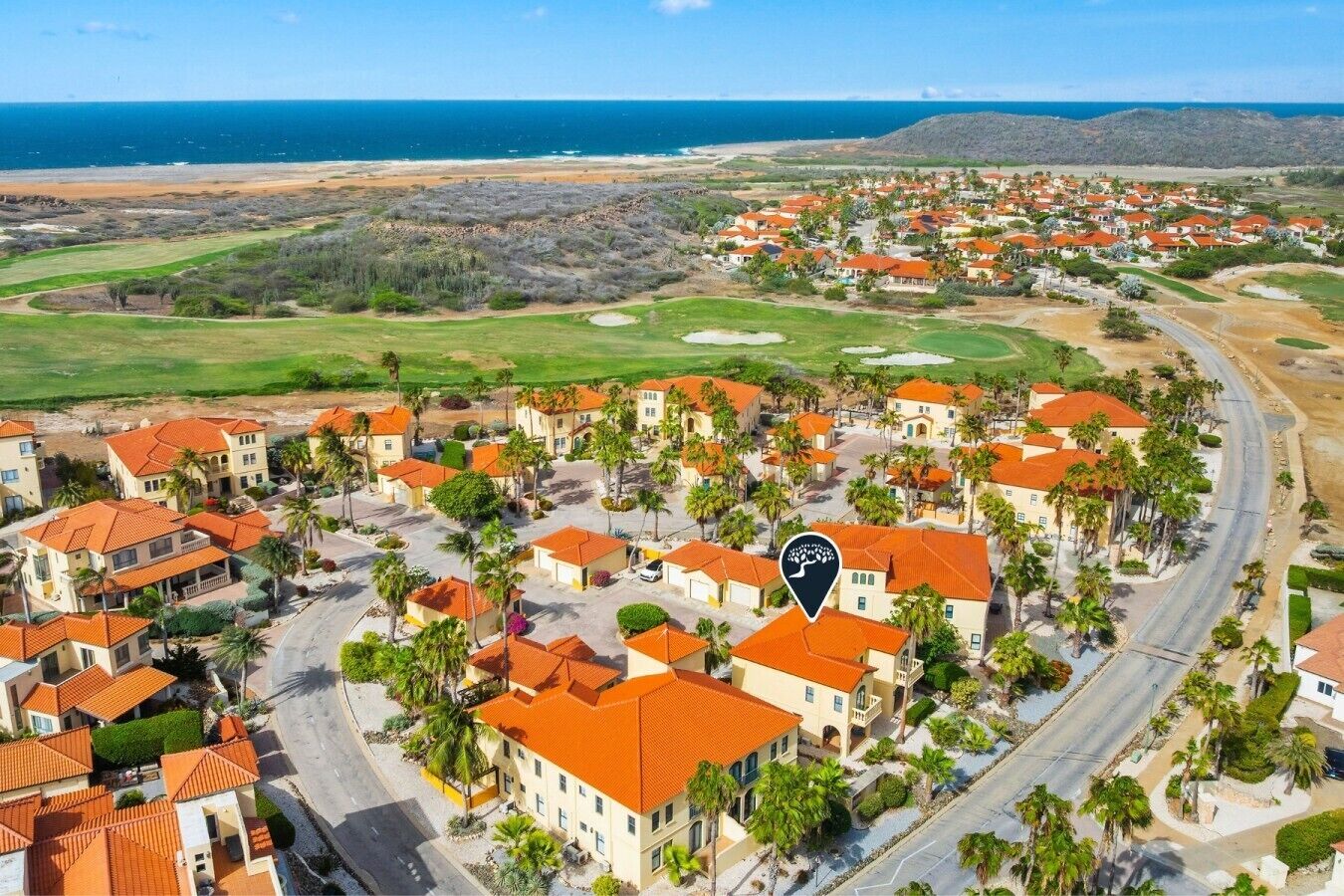 A coastal residential area with houses, roads, and a golf course.