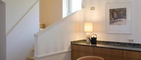 A staircase with a light fixture and a framed picture on the wall.