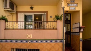 A building entrance with a balcony, a sign indicating 'EDF Trinidad N°35,' and a door leading inside.