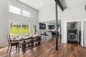 A spacious kitchen with a dining area, large windows, and a built-in washer and dryer. - Pikes Peak View  5 Private Acres Game Room (Colorado Springs)