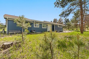 A single-story building with a flat roof, a front porch with a bench, and a small attached structure. - Pikes Peak View  5 Private Acres Game Room (Colorado Springs)
