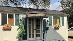 A house with a front door, windows, and a small porch. - Comfy quaint 1-bedroom cottage with serene pond area in charming Abbeville (Abbeville)
