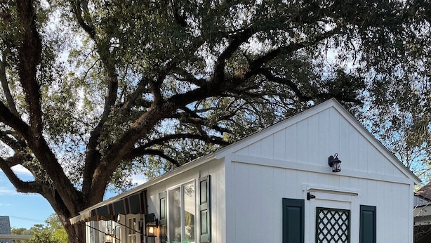 A small white building with a porch, steps, and a large tree in the background. - Comfy quaint 1-bedroom cottage with serene pond area in charming Abbeville (Abbeville)