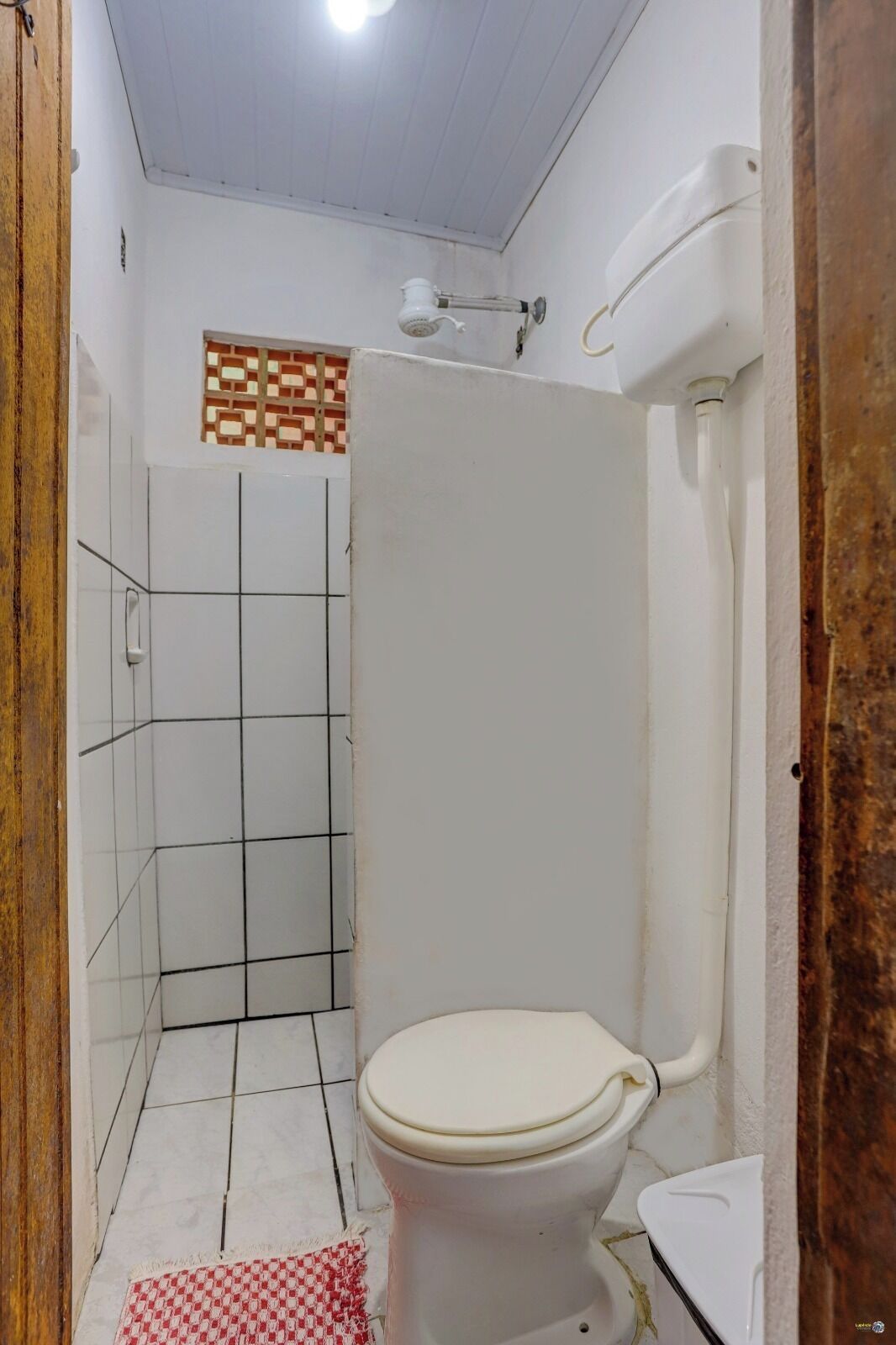 A bathroom with a toilet, shower, and tiled walls.
