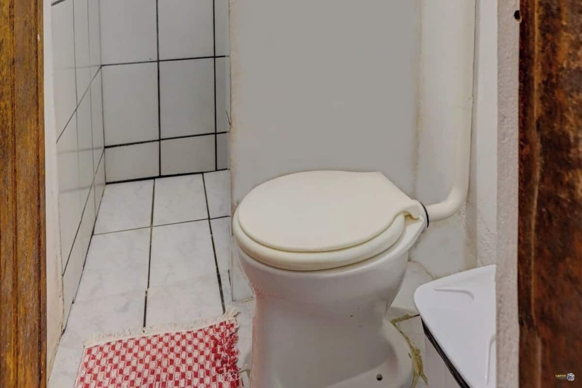 A bathroom with a toilet, shower, and tiled walls.