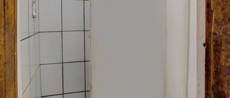 A bathroom with a toilet, shower, and tiled walls.